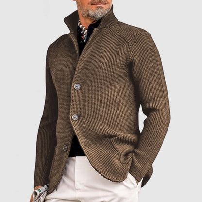 Brauner Strickblazer für Herren mit Knopfleiste, kombiniert mit weißer Hose. Eleganter, moderner Look für stilvolle Herbst- und Wintermode.