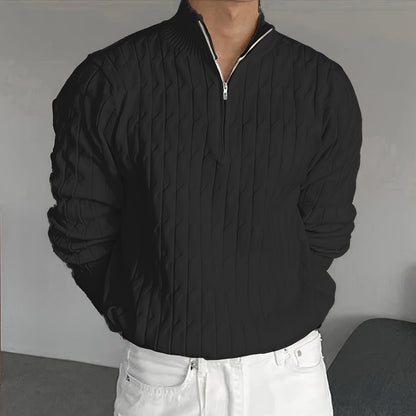 Schwarzer Strickpullover mit Reißverschluss, getragen von einer Person in weißer Hose. Modischer Herrenpullover, elegantes Design, Herbstmode.