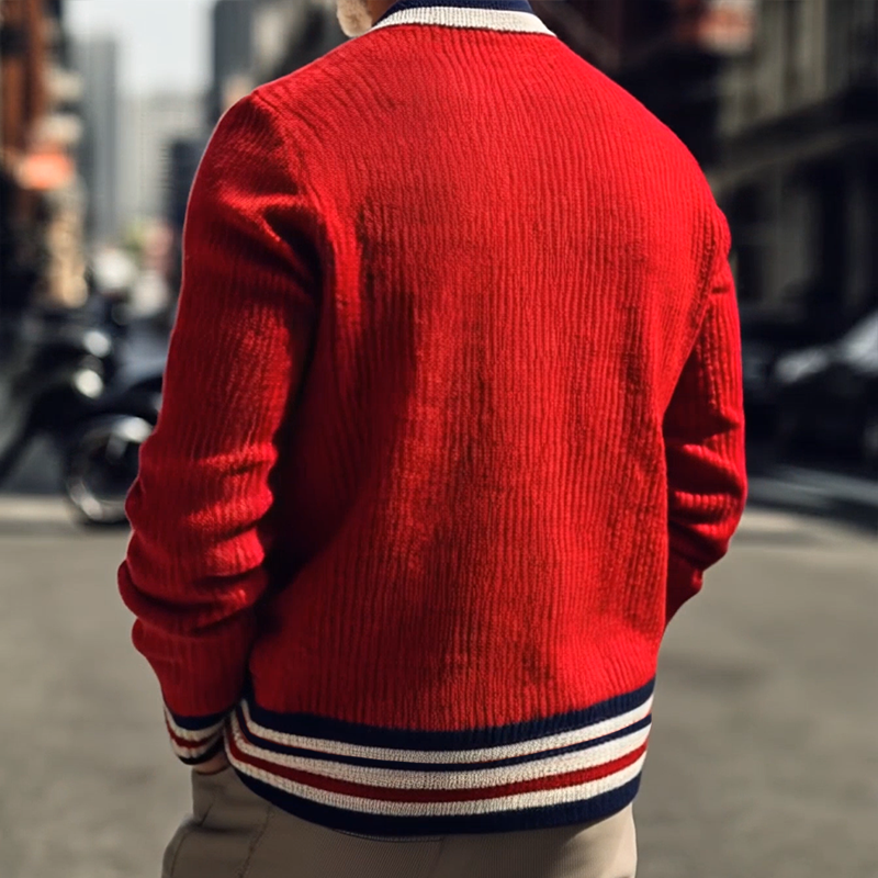 Roter Herrenpullover mit gestreiftem Kragen und Bündchen, modisch in urbaner Umgebung getragen. Streetwear, Herrenmode, stilvoller Look.