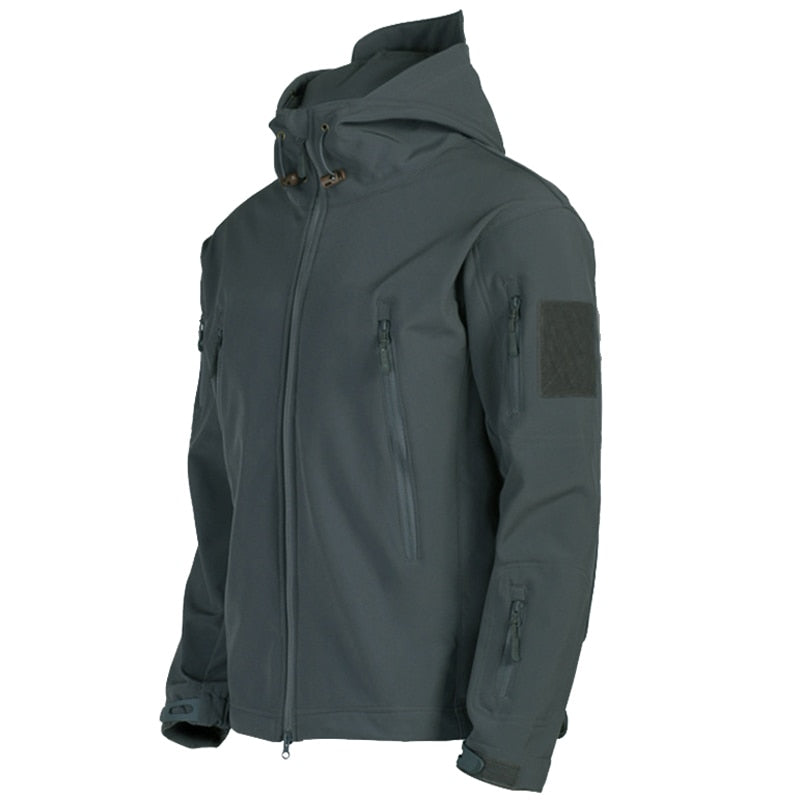Dunkelgraue Softshell-Jacke mit Kapuze, Reißverschlusstaschen und Klettverschluss am Ärmel. Outdoor-Bekleidung, wind- und wasserabweisend.
