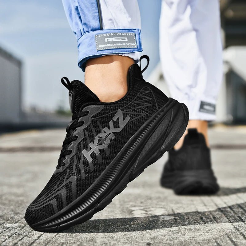 Schwarzer Sneaker auf Asphalt, sportliches Design, atmungsaktives Material, ideal für Laufen und Freizeit, moderne Herrenmode, bequeme Passform.