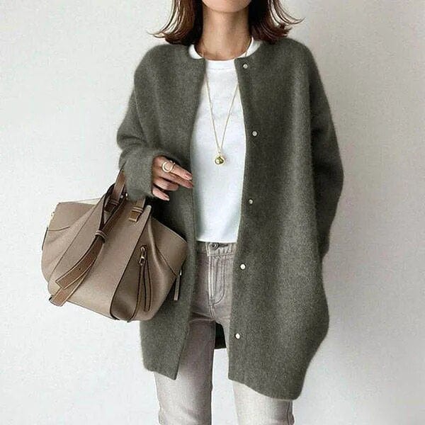 Frau in grauem Cardigan, weißem T-Shirt und beiger Hose hält eine beige Handtasche. Modetrend, Herbstmode, Damenbekleidung, eleganter Look.