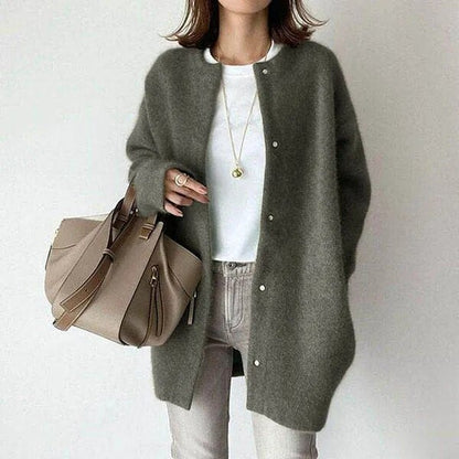 Frau in grauem Cardigan, weißem T-Shirt und beiger Hose hält eine beige Handtasche. Modetrend, Herbstmode, Damenbekleidung, eleganter Look.