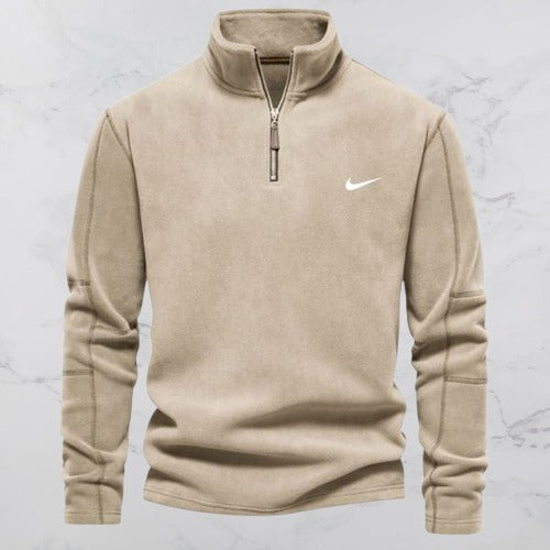 Beige Nike Fleece-Pullover mit Reißverschluss, Langarm, Stehkragen, auf Marmorhintergrund. Sportbekleidung, Herrenmode, Freizeitlook.