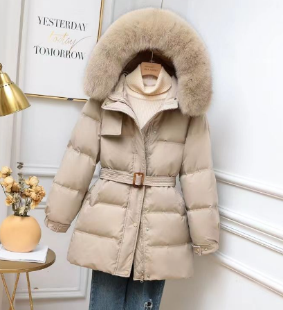 Beige Daunenjacke mit Fellkapuze, Gürtel und Reißverschluss, auf Kleiderbügel präsentiert. Wintermode, stilvoll, warm, Damenbekleidung.