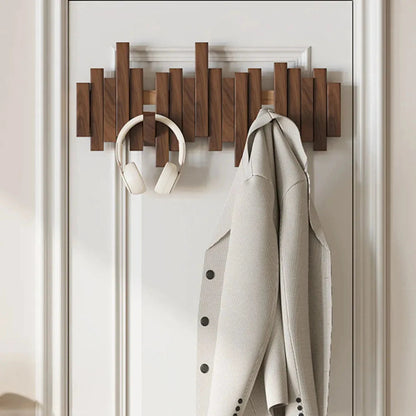 Holz-Wandgarderobe mit modernem Design, Kopfhörer und beigem Mantel. Praktische Aufbewahrungslösung für Flur oder Schlafzimmer.