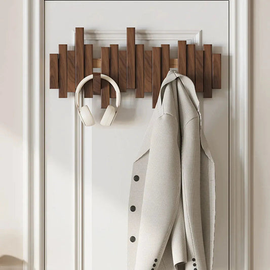 Holz-Wandgarderobe mit modernem Design, Kopfhörer und beigem Mantel. Praktische Aufbewahrungslösung für Flur oder Schlafzimmer.