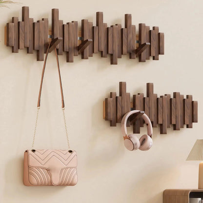 Moderne Holz-Wandgarderobe mit geometrischem Design, rosa Handtasche und Kopfhörer. Stilvolle Aufbewahrungslösung für Flur oder Wohnzimmer.