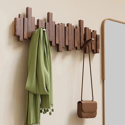 Moderne Holz-Garderobe mit geometrischem Design, grünem Schal und brauner Tasche. Stilvolle Wanddekoration, platzsparend und funktional.