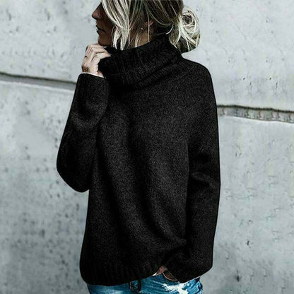 Frau in schwarzem Rollkragenpullover vor grauer Wand, lässiger Look, Herbstmode, Strickpullover, Damenbekleidung, modischer Stil.