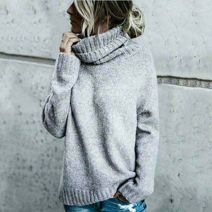 Frau in grauem Rollkragenpullover vor Betonwand, lässiger Look, Herbstmode, Strickpullover, Damenbekleidung, modischer Streetstyle.
