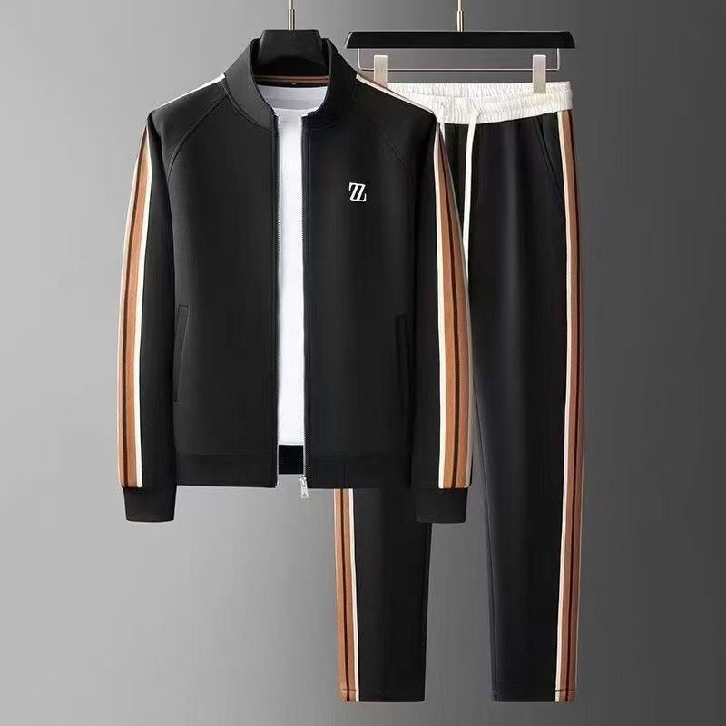 Schwarzer Trainingsanzug mit braunen und weißen Streifen, bestehend aus Jacke und Hose, auf grauem Hintergrund. Sportbekleidung, Herrenmode.