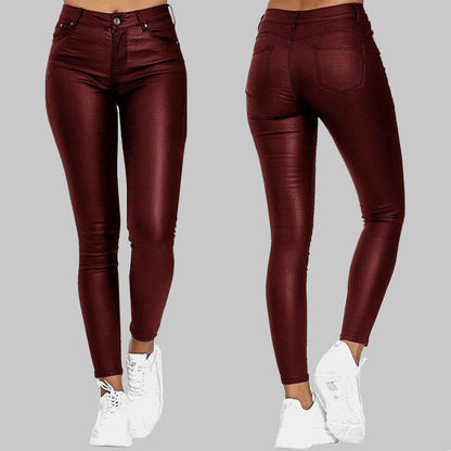 Damen-Leggings in Lederoptik, weinrot, figurbetont, mit Taschen, kombiniert mit weißen Sneakern. Modische Hose für trendige Outfits.