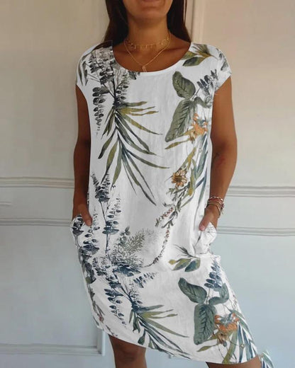 Frau in weißem Sommerkleid mit tropischem Blumenmuster, kurzen Ärmeln und Taschen. Perfekt für lässige Sommermode und Strandoutfits.