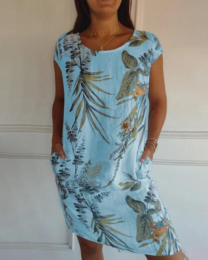 Frau in blauem, geblümtem Sommerkleid mit Taschen, tropisches Muster, lässiger Stil, modisches Freizeitoutfit, ideal für warme Tage.