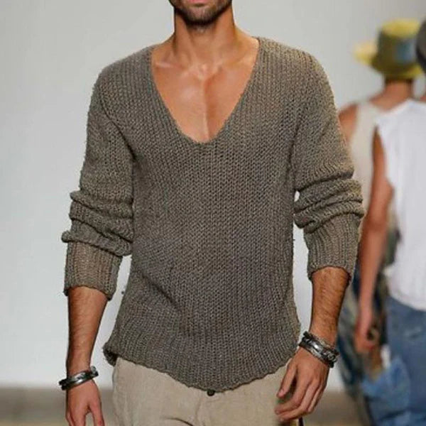 Mann in grauem Strickpullover mit V-Ausschnitt auf Laufsteg, modisches Herrenoutfit, lässiger Stil, Modeaccessoires, Armbänder.