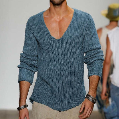 Mann trägt blauen Strickpullover mit V-Ausschnitt, kombiniert mit Armbändern. Modetrend, Herrenmode, lässiger Stil, Strickmode.