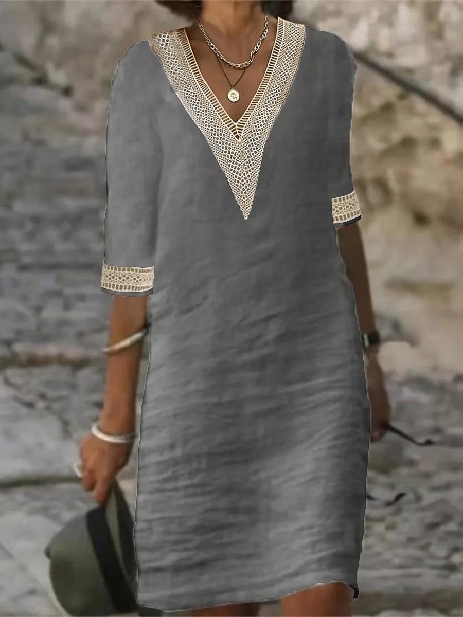 Graues Leinenkleid mit V-Ausschnitt und Spitzenbesatz, getragen von einer Person im Freien. Sommermode, lässiger Stil, elegantes Design.