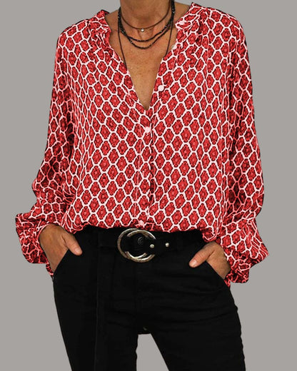 Rote Damenbluse mit geometrischem Muster, V-Ausschnitt und langen Ärmeln, kombiniert mit schwarzer Hose und Gürtel. Modetrend, stilvolle Damenbekleidung.