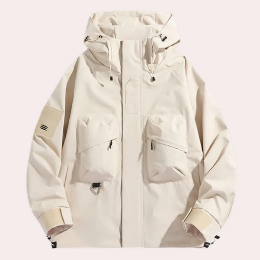 Beige Outdoor-Jacke mit Kapuze, zwei Fronttaschen und Reißverschlüssen. Funktionale Herrenjacke für Wandern und Trekking. Wetterfest und stylisch.