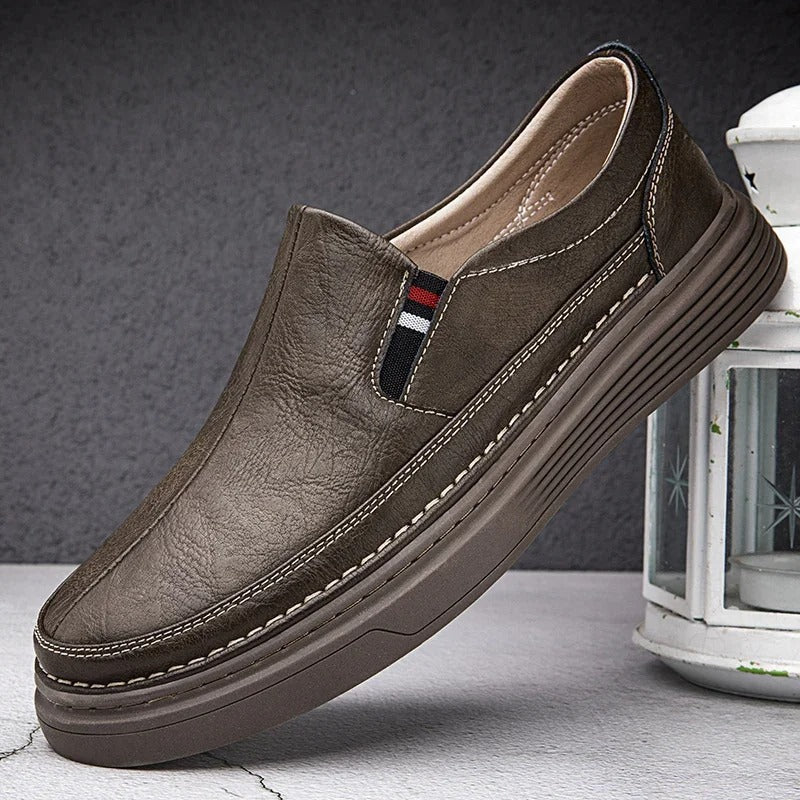 Brauner Herren-Slipper aus Leder mit rutschfester Sohle, elegantem Design und Zierstreifen, ideal für Freizeit und Business.