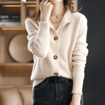 Dame in cremefarbenem Strickpullover mit Knopfleiste, kombiniert mit dunkler Jeans. Elegante Herbstmode, gemütlicher Look, modischer Stil.