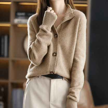 Frau trägt beige Strickjacke mit Knöpfen und langen Ärmeln, kombiniert mit heller Hose. Modetrend Herbst, gemütlicher Look, eleganter Stil.