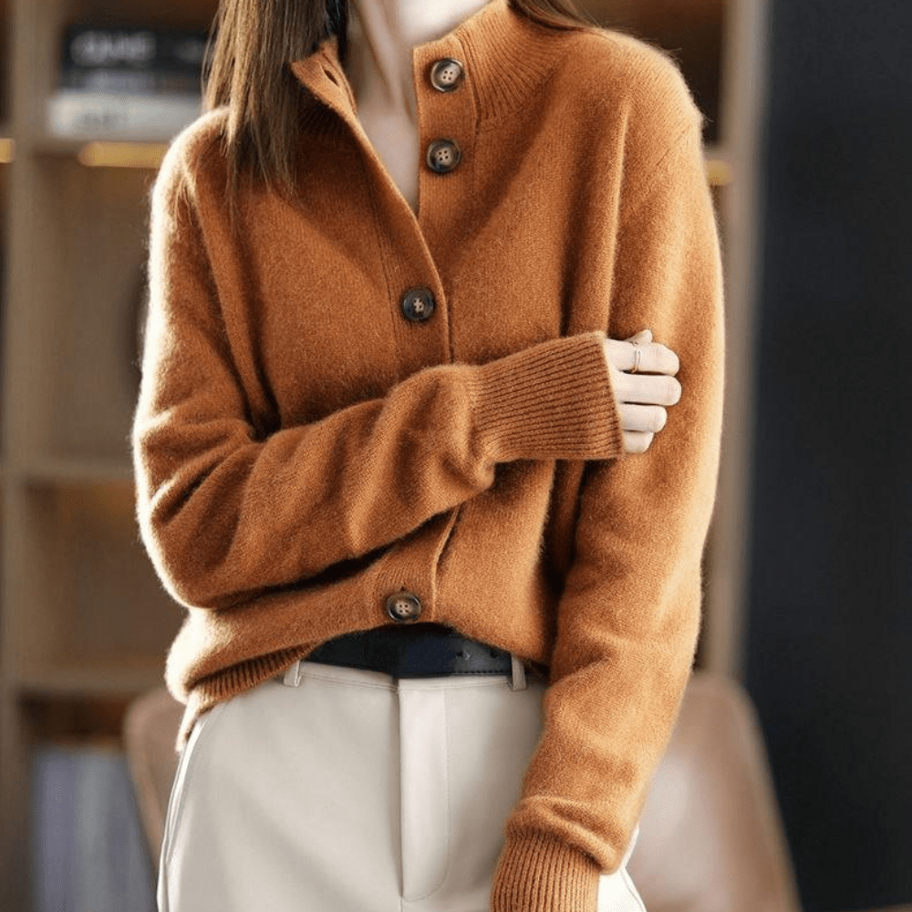 Damenmode: Frau trägt braunen Strickpullover mit Knopfleiste, kombiniert mit beigen Hosen. Eleganter Herbstlook, gemütlich und stilvoll.