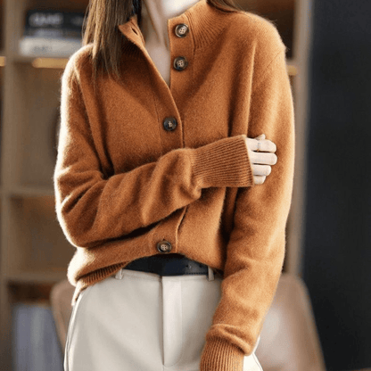 Damenmode: Frau trägt braunen Strickpullover mit Knopfleiste, kombiniert mit beigen Hosen. Eleganter Herbstlook, gemütlich und stilvoll.