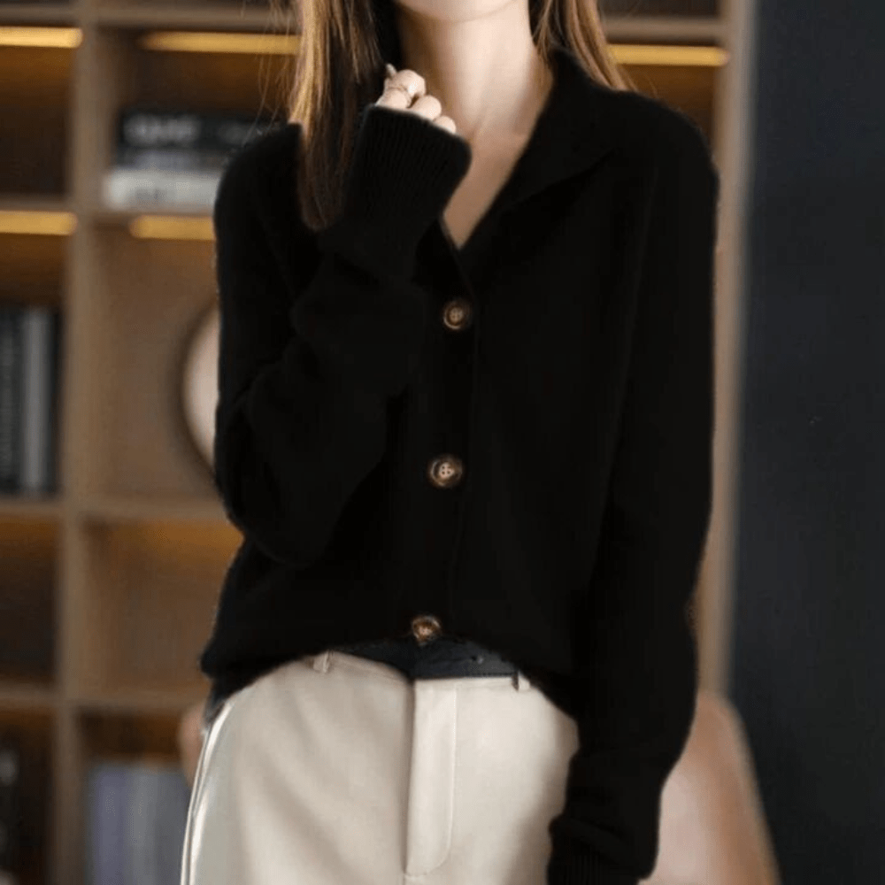 Frau in schwarzem Strickpullover mit Knöpfen, beige Hose, vor Bücherregal. Modetrend, Herbstmode, eleganter Freizeitlook.