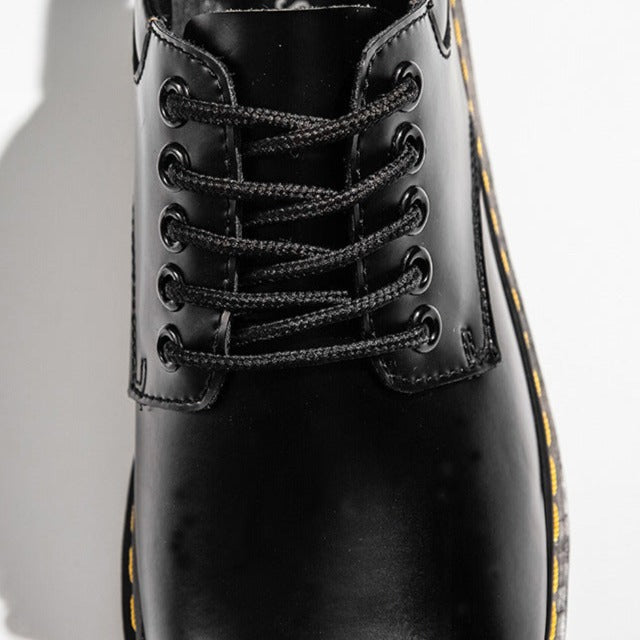 Schwarzer Lederstiefel mit gelber Naht, Nahaufnahme der Vorderseite, Schnürsenkel, modisch, robust, ideal für Herbst- und Wintermode.
