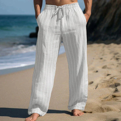 Person in weißen Leinenhosen am Strand, entspannte Sommermode, lässige Strandkleidung, Herrenbekleidung, ideal für warme Tage.