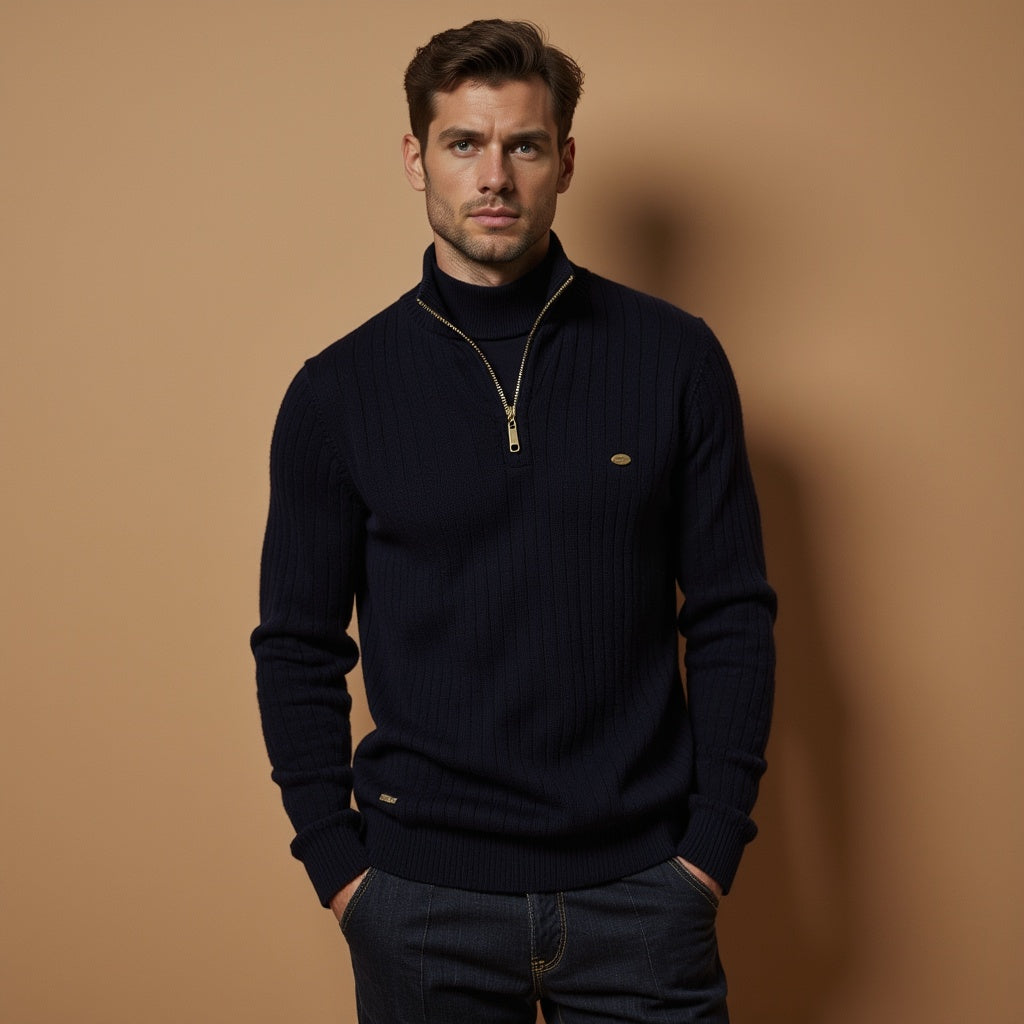 Ein Mann trägt einen dunkelblauen Strickpullover mit Reißverschluss vor einem beigefarbenen Hintergrund. Elegante Herrenmode, stilvoller Look.
