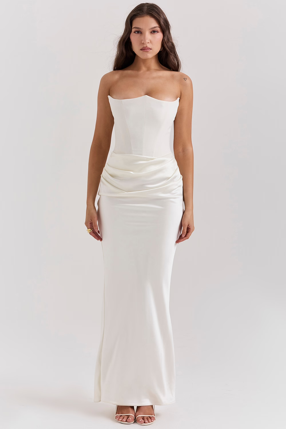 Frau in elegantem, trägerlosem weißen Abendkleid mit figurbetontem Schnitt und fließendem Rock, ideal für formelle Anlässe und Hochzeiten.