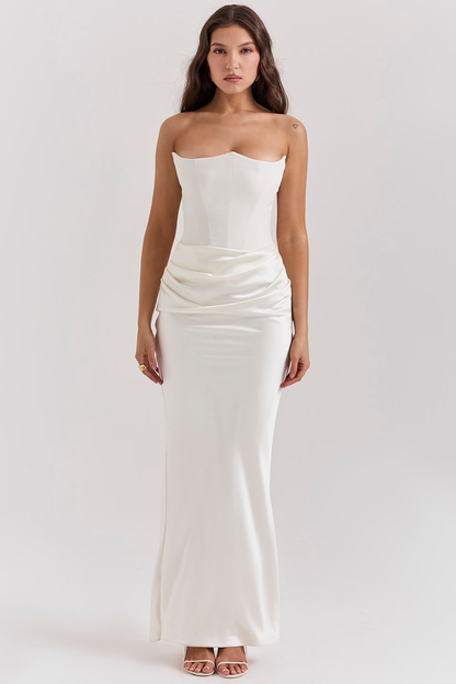 Frau in elegantem, trägerlosem weißen Abendkleid mit figurbetontem Schnitt und fließendem Rock, ideal für formelle Anlässe und Hochzeiten.