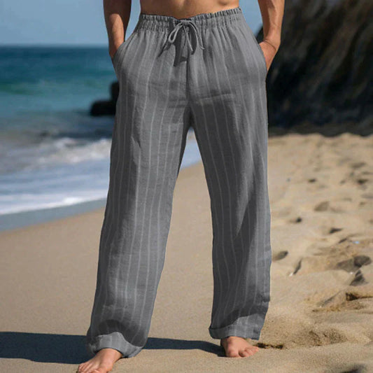 Graue Leinenhose am Strand, lässig und bequem, ideal für Sommermode. Perfekt für Strandspaziergänge und entspannte Freizeitkleidung.