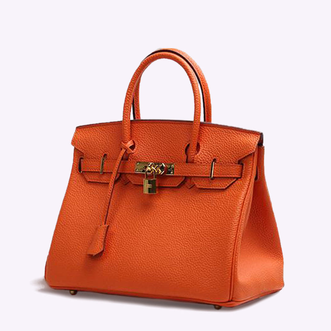 Luxuriöse orangefarbene Designer-Handtasche aus Leder mit goldenen Beschlägen und Schloss, ikonisches Modeaccessoire, elegant und stilvoll.