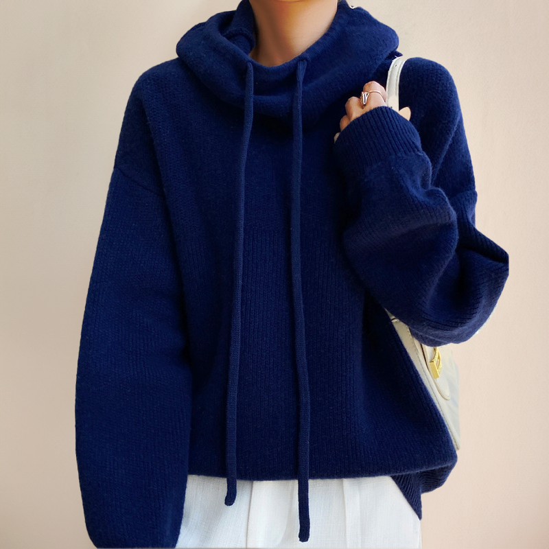 Dunkelblauer Strickpullover mit Kapuze und Kordeln, getragen von Person. Modischer, bequemer Winterpullover für Damen. Ideal für kalte Tage.