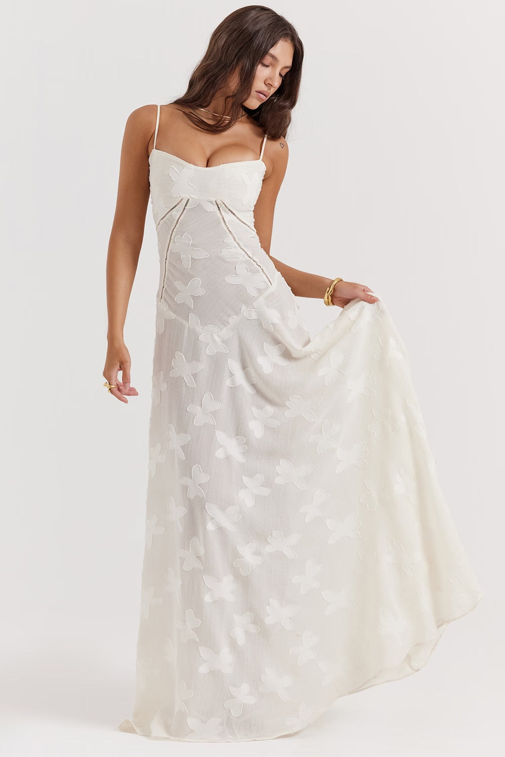 Frau in weißem, ärmellosem Maxikleid mit Blumenmuster, elegantes Sommeroutfit, modisches Design, ideal für Hochzeiten oder besondere Anlässe.