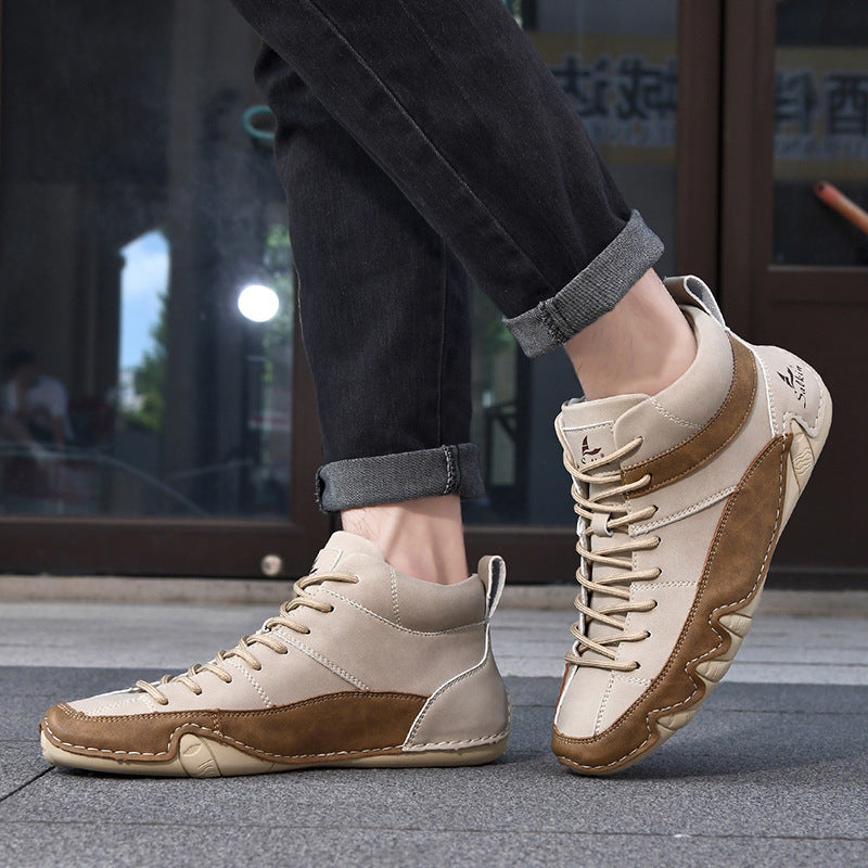 Beige-braune Herren-Sneaker aus Leder, getragen mit hochgekrempelten schwarzen Jeans, urbaner Hintergrund. Modische Freizeitschuhe für Männer.