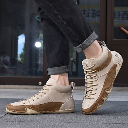 Beige-braune Herren-Sneaker aus Leder, getragen mit hochgekrempelten schwarzen Jeans, urbaner Hintergrund. Modische Freizeitschuhe für Männer.