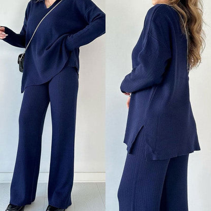 Damen-Outfit in Dunkelblau: Strickpullover und weite Hose, kombiniert mit schwarzer Umhängetasche. Modischer, bequemer Look für Herbst/Winter.