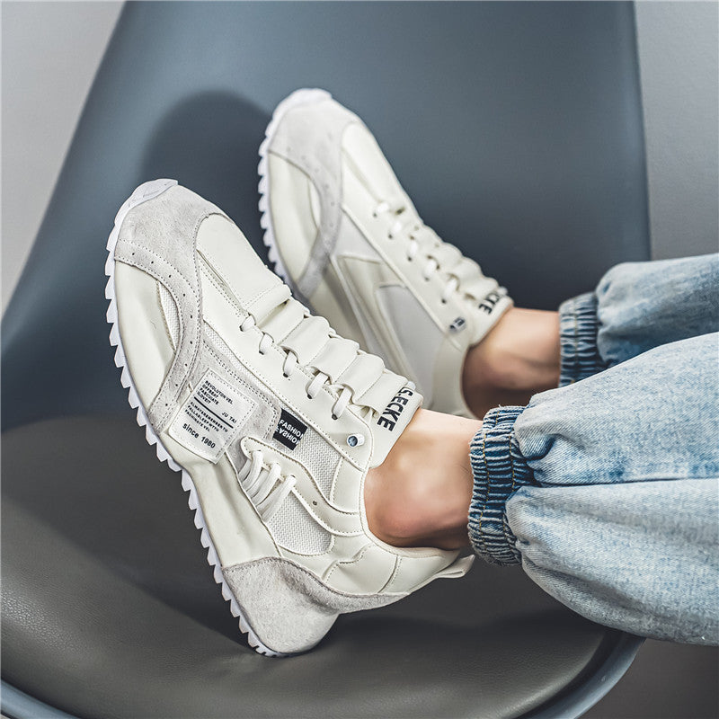 Weiße Sneaker auf grauem Stuhl, getragen von Person in blauen Jeans. Modische Turnschuhe, sportlicher Stil, bequeme Freizeitschuhe für Damen und Herren.