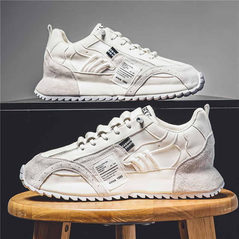 Weiße Sneaker mit Wildleder- und Mesh-Details auf Holzstuhl, modisches Design, sportlich, lässig, ideal für Herrenmode und Streetwear-Trends.