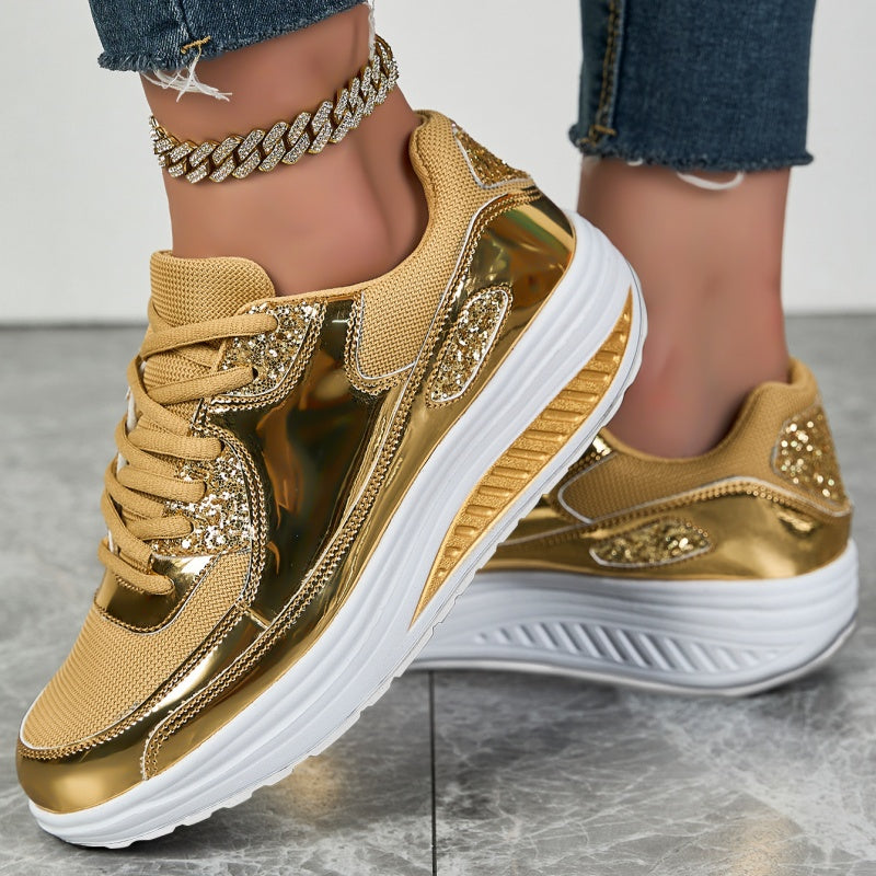 Goldene Sneaker mit glänzenden Details und weißer Sohle, getragen mit Jeans und einer goldenen Fußkette. Modische Damenschuhe, trendiger Look.