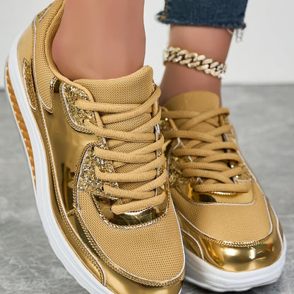 Goldene Sneaker mit glänzenden Metallic-Details und weißer Sohle, getragen mit Jeans und goldener Fußkette. Modische Damenschuhe, trendiger Look.