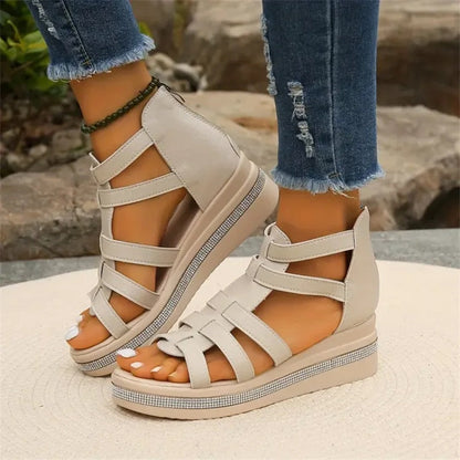 Damen Sandalen mit Keilabsatz, beige, Kreuzriemen, lässig, kombiniert mit zerrissenen Jeans, Outdoor-Hintergrund, modisch, bequem.