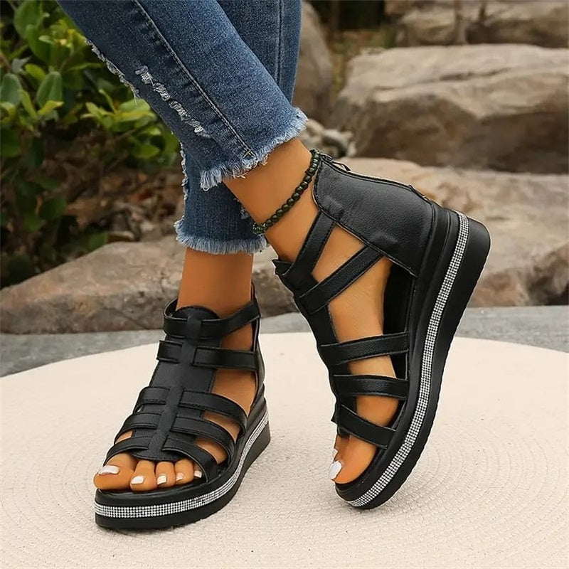 Schwarze Sandalen mit Plateauabsatz, getragen von einer Person in zerrissenen Jeans. Modische Sommerschuhe, ideal für Freizeit und Outdoor.