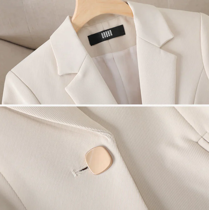 Eleganter cremeweißer Blazer aus Baumwolle auf Holzkleiderbügel, Nahaufnahme mit Knopfdetail, ideal für Business-Mode und stilvolle Outfits.