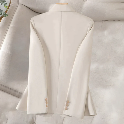 Beiger Damenblazer auf beigem Sofa, elegantes Design, lange Ärmel, Knöpfe an den Manschetten, stilvolle Damenmode, Business-Outfit.